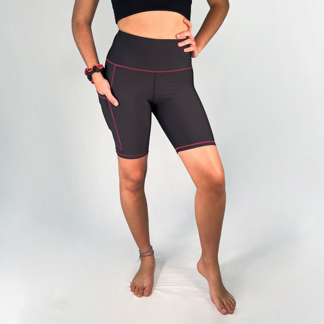 Front view of bike shorts with pocket in Black with pink stitching design by Art2Go Monique Baques