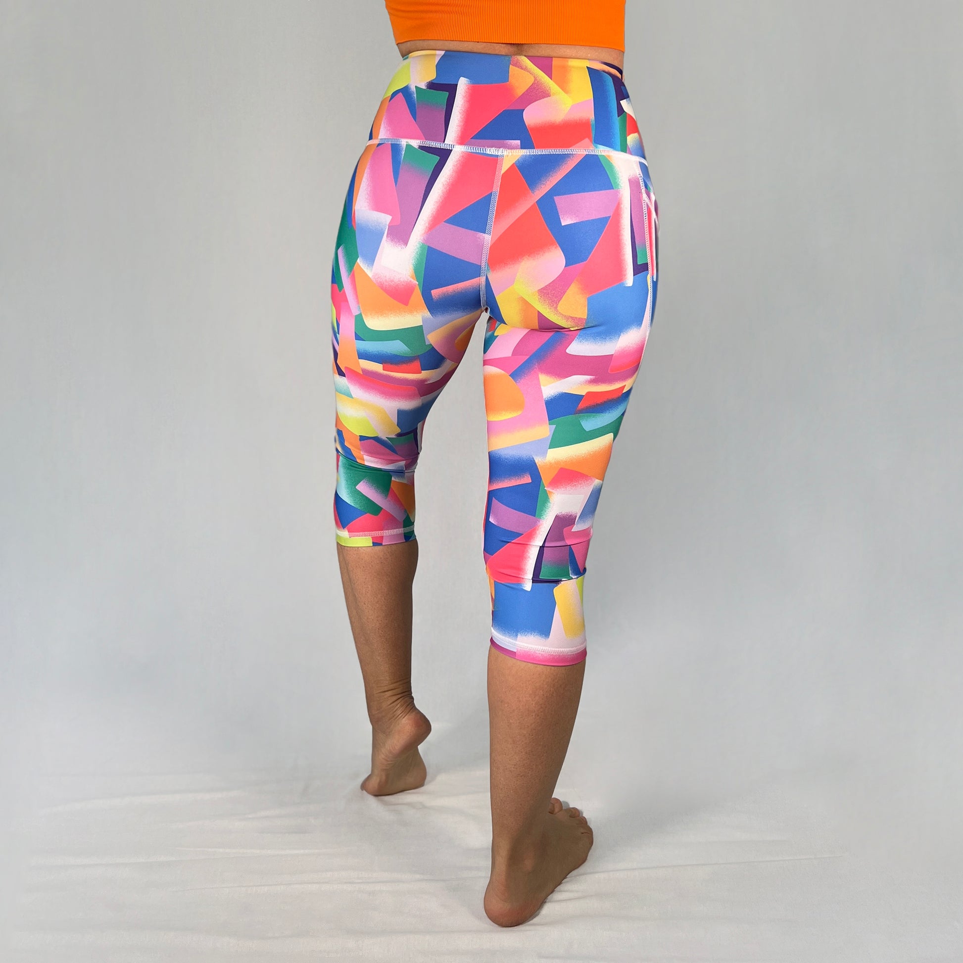 Back view of colourful 3/4-length leggings with pocket in Festive design by Art2Go Monique Baques